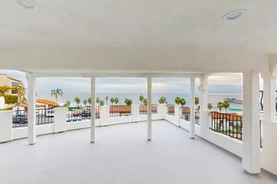 a large white balcony with a view of the ocean at Cozy Couples Escape! Walk to San Clemente Pier in San Clemente