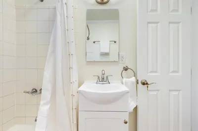 a white bathroom with a sink and a mirror at Cozy Couples Escape! Walk to San Clemente Pier in San Clemente