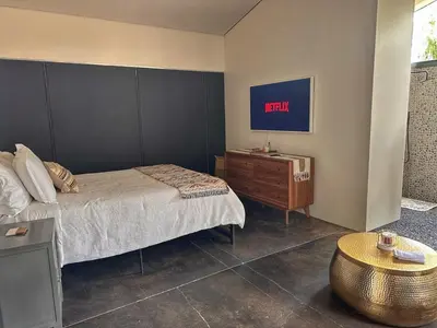 a bedroom with a bed and a nightstand with a clock on the wall at Laguna Beach Best Kept Secret Complete Ocean View in Laguna Beach