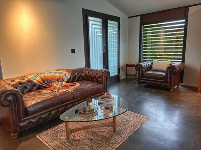 a living room with a brown leather couch and a glass table at Laguna Beach Best Kept Secret Complete Ocean View in Laguna Beach