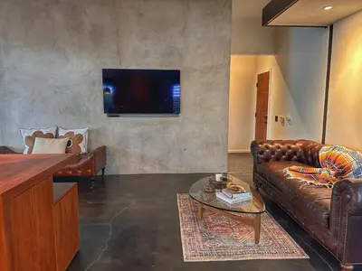 a living room with a leather couch and a tv at Laguna Beach Best Kept Secret Complete Ocean View in Laguna Beach