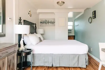 a bedroom with a white bed and a lamp at Laguna Cove Hotel in Laguna Beach