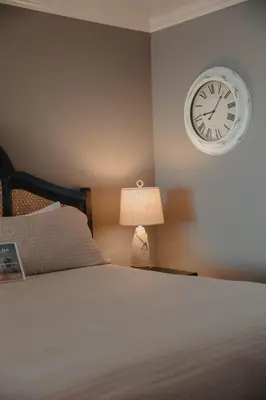 a bedroom with a bed and a clock on the wall at Laguna Cove Hotel in Laguna Beach