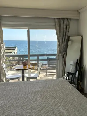 a bedroom with a bed and a view of the ocean at Laguna Cove Hotel in Laguna Beach