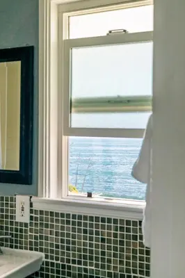 a bathroom with a window with a view of the ocean at Laguna Cove Hotel in Laguna Beach