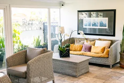 a living room with wicker chairs and a couch at Laguna Cove Hotel in Laguna Beach