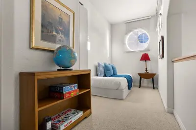 a living room with a bed and a book shelf at Encinitas Retreat Private Pool and Spa Short Drive to Beach in Encinitas
