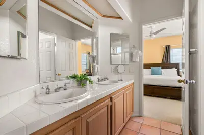 a bathroom with two sinks and a bedroom at Encinitas Retreat Private Pool and Spa Short Drive to Beach in Encinitas