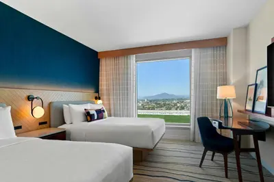 a hotel room with two beds and a desk and a window at Gaylord Pacific Resort & Convention Center in Chula Vista
