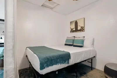 a white bed with two pillows on it in a room at Next to Downtown Huge yard with Parking in San Diego