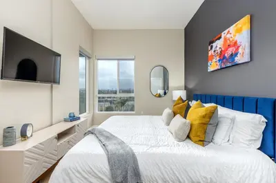 a bedroom with a large bed with yellow pillows at Artistic FastWiFi Parking Pets in San Diego