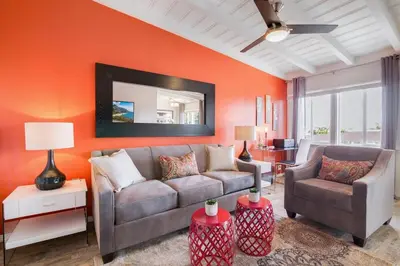 a living room with orange walls and a couch and chairs at Coastal Escape King 1Bd, Pets Parking Fast Wi-Fi in San Clemente