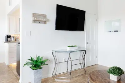 a living room with a table and a tv on a wall at Seaside King 1bd Haven, Pets, Fast Wi-Fi Parking in San Clemente