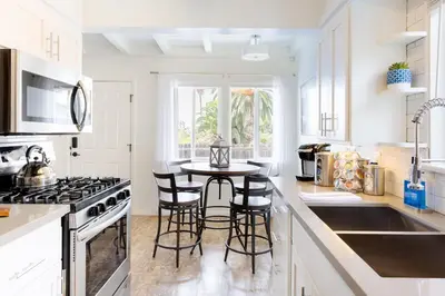 a white kitchen with a table and some chairs at Seaside King 1bd Haven, Pets, Fast Wi-Fi Parking in San Clemente