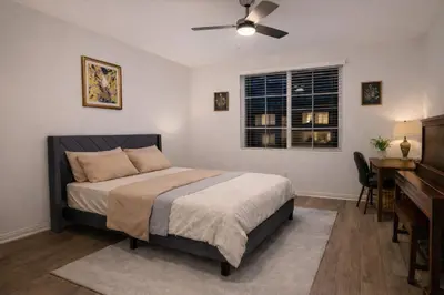 a bedroom with a bed with a ceiling fan and a desk at 6 BR Pool & Games Retreat - Summer Near Wineries in Winchester