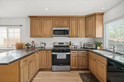 a kitchen with wooden cabinets and a stove top oven at Fun Family Retreat Games, Massage Chair & Yard in Mission Viejo