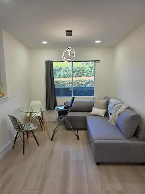 a living room with a couch and a table and a window at Ocean View, Sand, Waves & Wonder in Dana Point