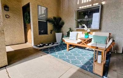 a porch with two chairs and a table on a rug at Ocean View, Sand, Waves & Wonder in Dana Point