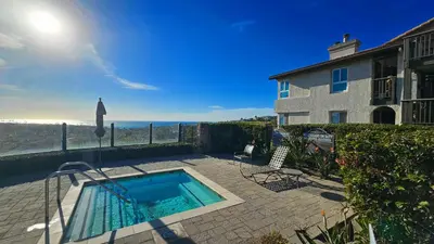 a swimming pool in front of a house at Ocean View, Sand, Waves & Wonder in Dana Point