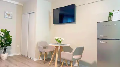 a dining room with a table and chairs and a refrigerator at Haven Vibe in Escondido