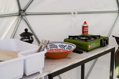 a counter with a stove and a bowl on a shelf at A Quiet Fireside Retreat in a Scenic Glamping Dome in Fallbrook