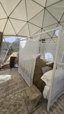 a bedroom with a canopy bed in a tent at A Quiet Fireside Retreat in a Scenic Glamping Dome in Fallbrook