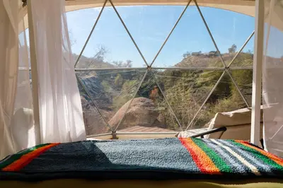 a window with a colorful blanket in front of it at A Quiet Fireside Retreat in a Scenic Glamping Dome in Fallbrook