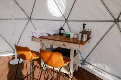 a wooden table in a yurt with two chairs at A Cozy Fireside Glamping Escape with Ridge Views in Fallbrook