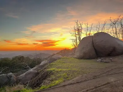 a rock on a hill with a sunset in the background at Cozy Dome Hideaway with Sweeping Sunrise View in Fallbrook