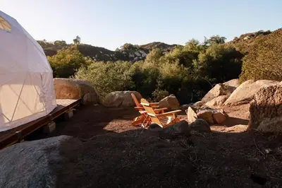 a tent and a bench next to some rocks at Cozy Dome Hideaway with Sweeping Sunrise View in Fallbrook