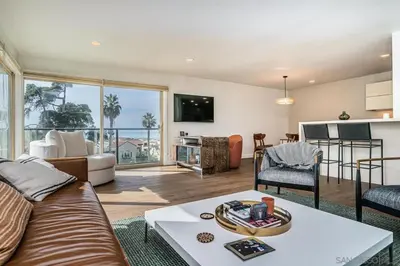 a living room with a couch and a table at Top Floor Oceanfront Condo in San Diego
