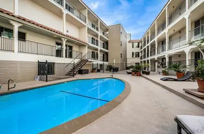 a swimming pool in the courtyard of a apartment building at Top Floor Oceanfront Condo in San Diego