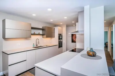 a kitchen with white cabinets and a counter top at Top Floor Oceanfront Condo in San Diego