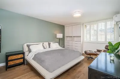 a bedroom with a large bed and a table at Top Floor Oceanfront Condo in San Diego