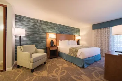 a hotel room with a bed and a chair at Winners Circle Resort in Solana Beach