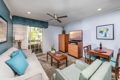 a living room with a couch and a tv at Winners Circle Resort in Solana Beach