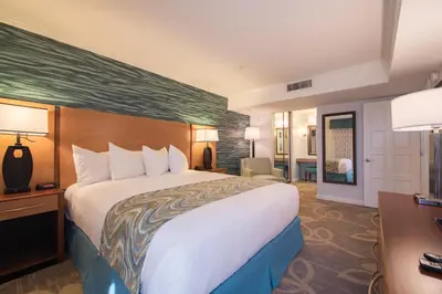 a hotel room with a large bed and a desk at Winners Circle Resort in Solana Beach