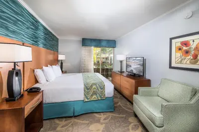 a hotel room with a bed and a chair at Winners Circle Resort in Solana Beach