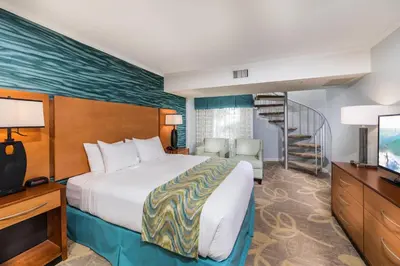 a hotel room with a bed and a television at Winners Circle Resort in Solana Beach