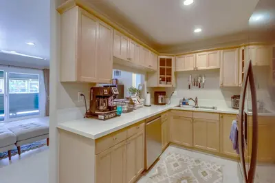 a kitchen with wooden cabinets and a large window at Entire Private Home with 3 Bedrooms 2 Bathrooms, Family Home Free Pool, Tub and Parking, Available Now in Chula Vista