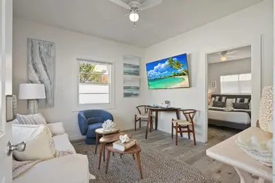 a living room with a couch and a table at Draper Bungalow By CoastVH - Charming 1940 in San Diego