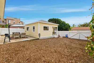 a yellow house with a patio and a fence at Draper Bungalow By CoastVH - Charming 1940 in San Diego