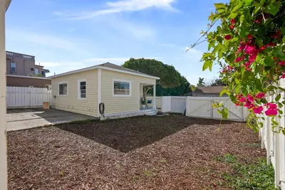 a white house with a fence and a yard at Draper Bungalow By CoastVH - Charming 1940 in San Diego