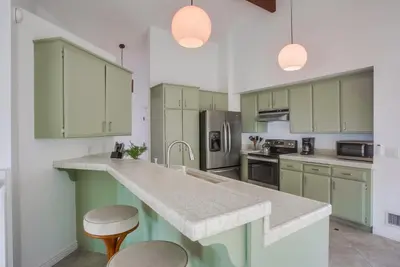 a kitchen with green cabinets and a granite counter top at Cardiff View in Cardiff-by-the-Sea