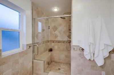 a bathroom with a shower with a glass door at Cardiff View in Cardiff-by-the-Sea
