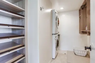 a laundry room with a refrigerator and shelves at Marine Dream in San Diego
