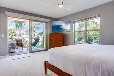 a bedroom with a large white bed and windows at Marine Dream in San Diego