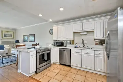 a kitchen with white cabinets and a stainless steel refrigerator at La Costa Condo Pool BBQ Gated Parking in Carlsbad