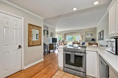 a kitchen with a stove and a living room at La Costa Condo Pool BBQ Gated Parking in Carlsbad