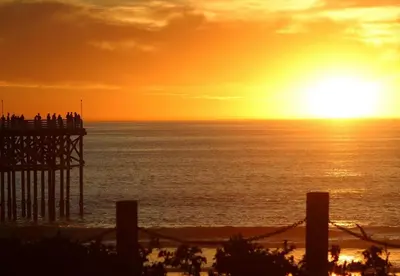 a sunset over the ocean with a pier at 500 ft to Ocean Relaxing stay Parking WiFi 834 in San Diego
